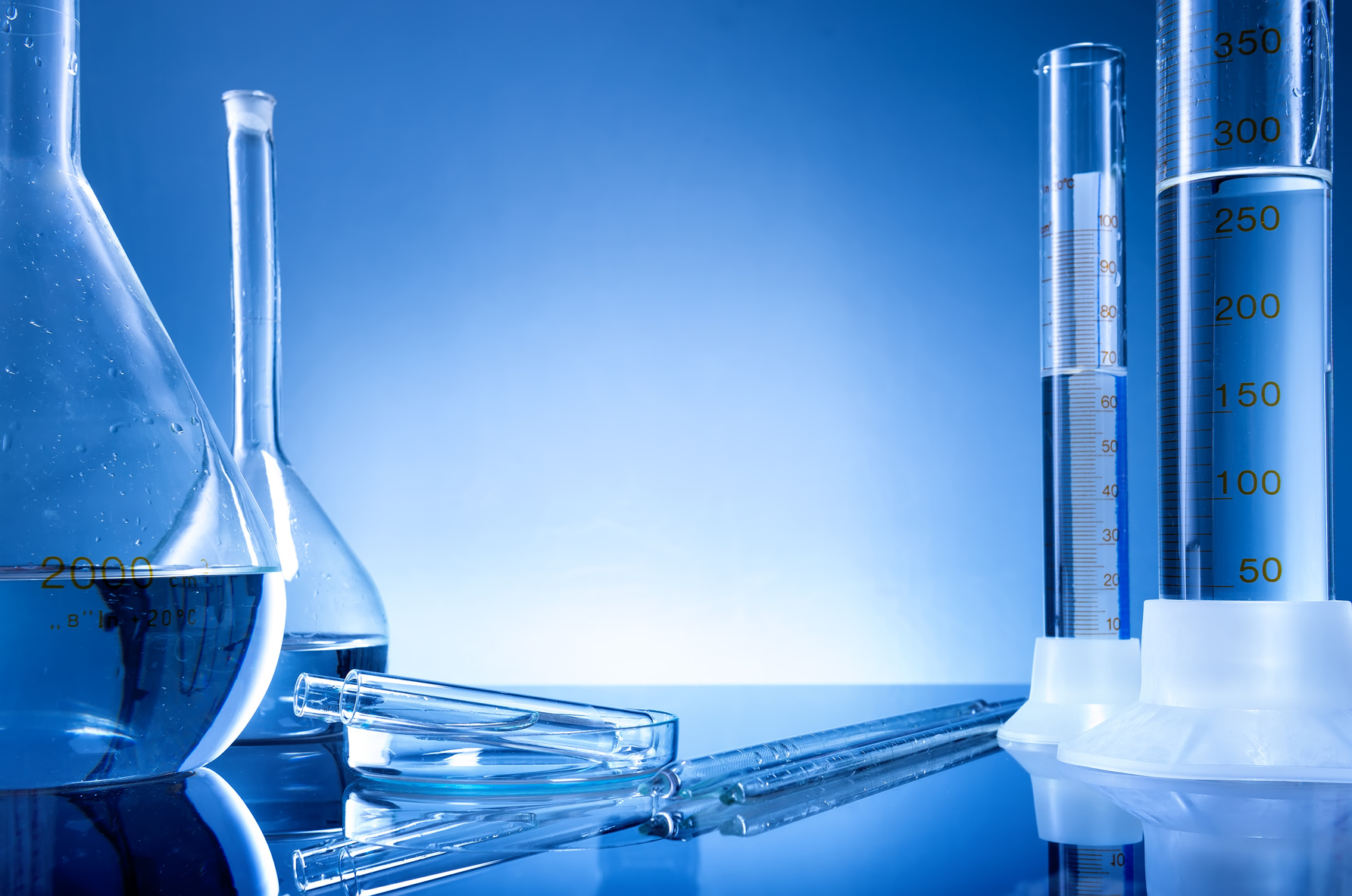 Laboratory equipment, bottles, flasks on blue background